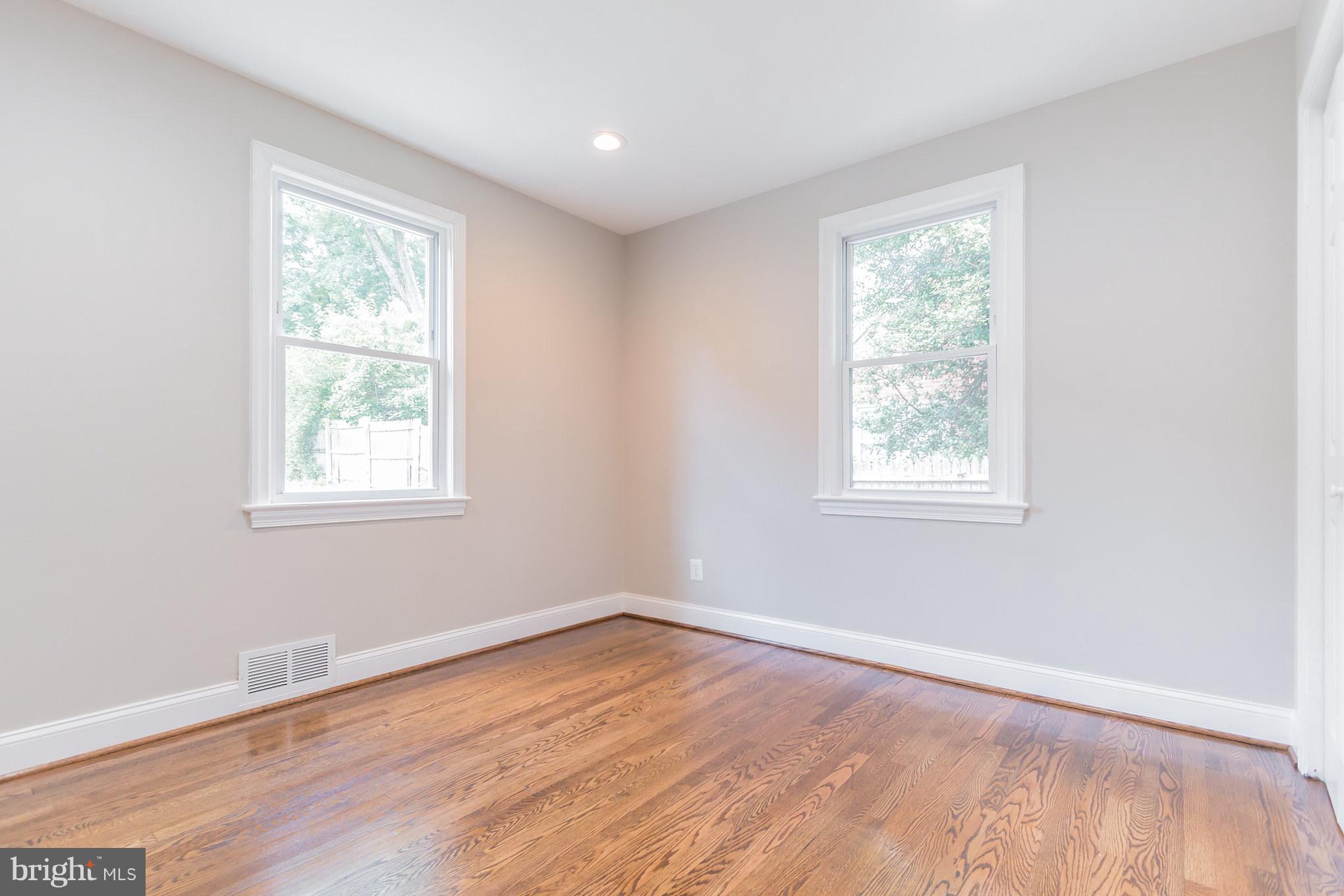 11508 Veirs Mill Road Silver Spring, MD 20902 - Photo 13 of 30 an empty room with wooden floor and windows