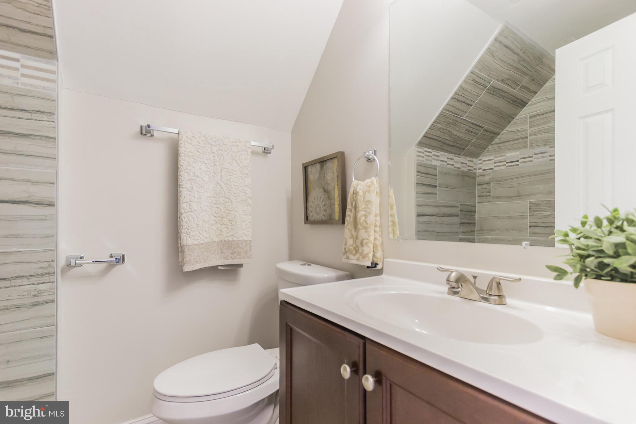 11508 Veirs Mill Road Silver Spring, MD 20902 - Photo 20 of 30 a bathroom with a granite countertop sink a toilet and a mirror