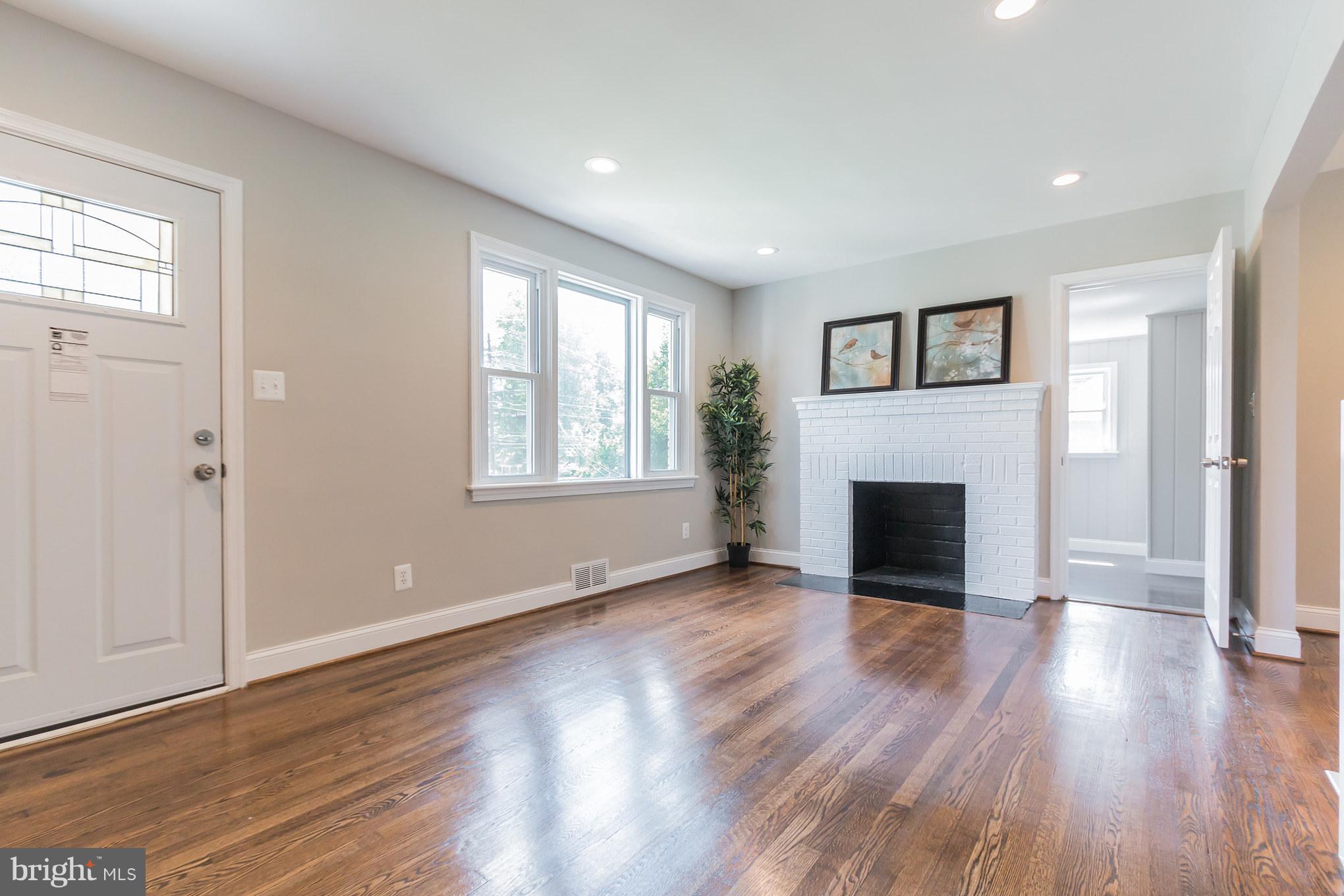 11508 Veirs Mill Road Silver Spring, MD 20902 - Photo 3 of 30 a view of a livingroom with wooden floor and a fireplace
