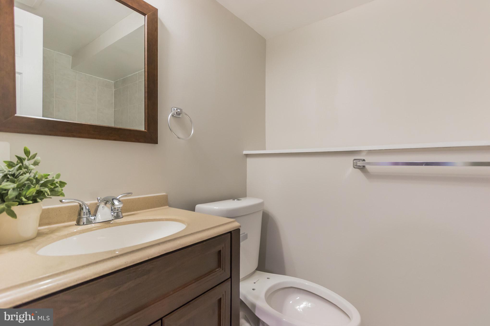 11508 Veirs Mill Road Silver Spring, MD 20902 - Photo 26 of 30 a bathroom with a granite countertop toilet sink and mirror