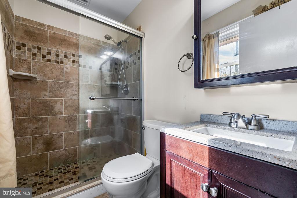 577 Brock Bridge Road Laurel, MD 20724 - Photo 14 of 41 a bathroom with a granite countertop sink toilet a mirror and shower