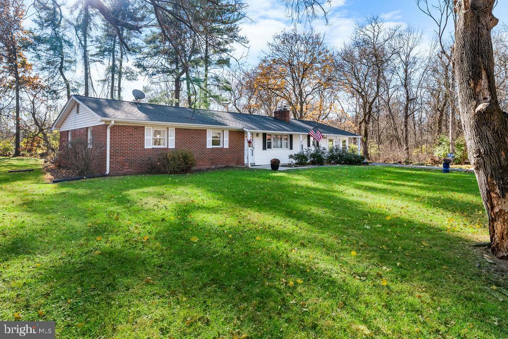 577 Brock Bridge Road Laurel, MD 20724 - Photo 31 of 41 a house that is sitting in the grass with large trees and plants