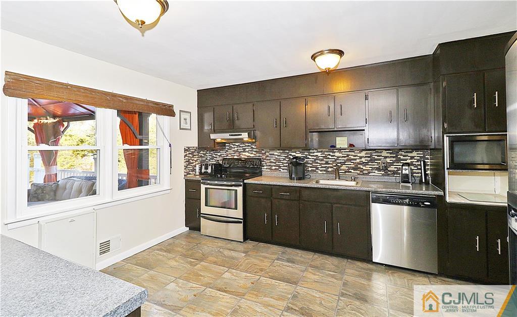 64 Valley Road Jackson, NJ 08527 - Photo 11 of 24 a kitchen with stainless steel appliances kitchen island granite countertop a stove a sink and a microwave