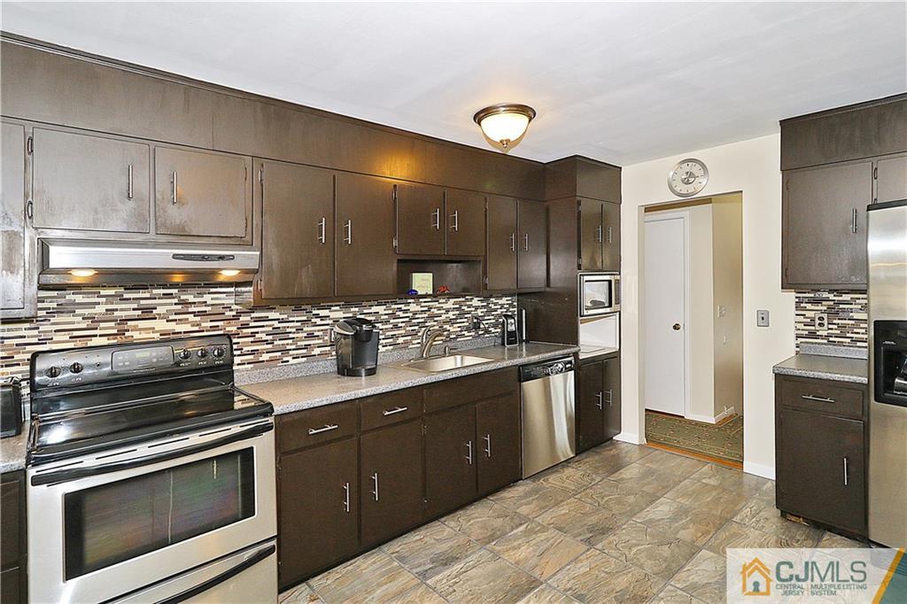 64 Valley Road Jackson, NJ 08527 - Photo 10 of 24 a kitchen with stainless steel appliances kitchen island granite countertop a stove and a refrigerator