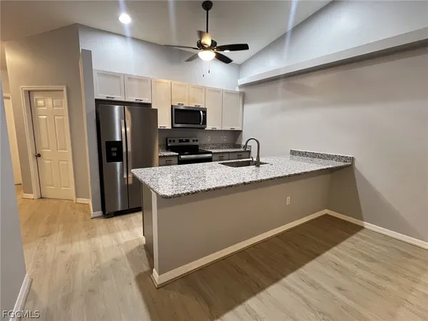 a kitchen with stainless steel appliances granite countertop a sink refrigerator and microwave