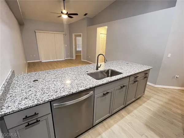 a kitchen with granite countertop a sink and cabinets