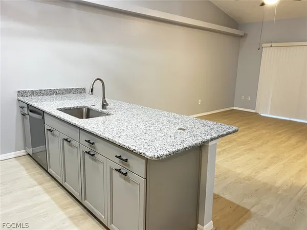 a utility room with granite countertop a sink and vanity