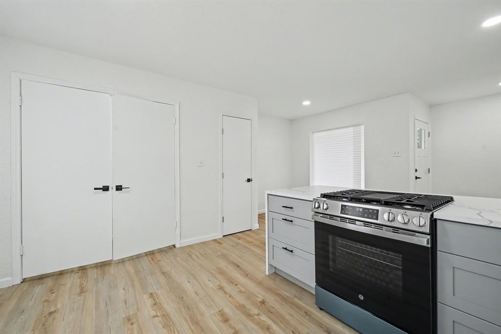 11446 Lippitt Avenue Dallas, TX 75218 - Photo 10 of 26 a kitchen with a stove and white cabinets