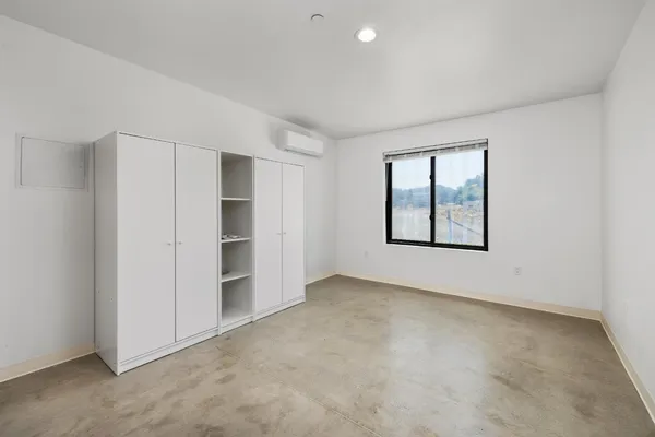 a view of an empty room with closet and a window