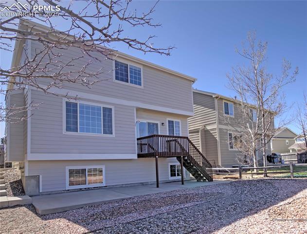 686 Pebble Crest Way Colorado Springs, CO 80921 - Photo 26 of 30 Maintanence free bac with backyard with large concrete patio and sidewalk to left leading to front of the house.