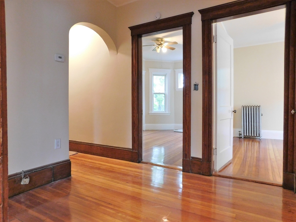 17 Manley Street, Unit 2 Boston, MA 02122 - Photo 11 of 16 an empty room with wooden floor and a mirror