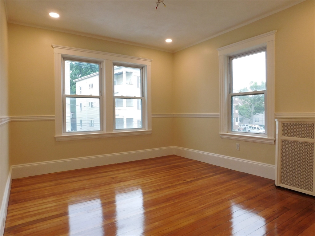 17 Manley Street, Unit 2 Boston, MA 02122 - Photo 9 of 16 a view of an empty room with wooden floor and a window