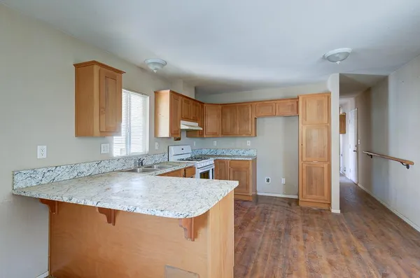 a kitchen with stainless steel appliances granite countertop a sink stove and refrigerator