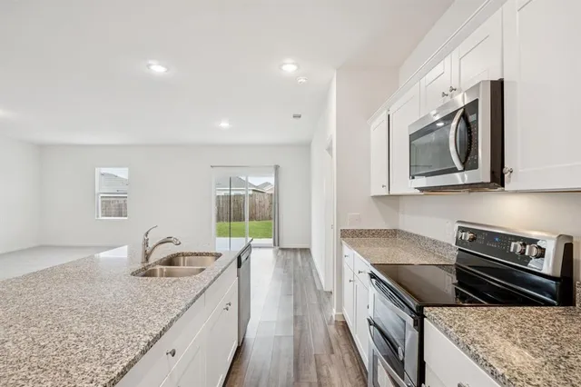 a kitchen with stainless steel appliances granite countertop a sink and stove top oven