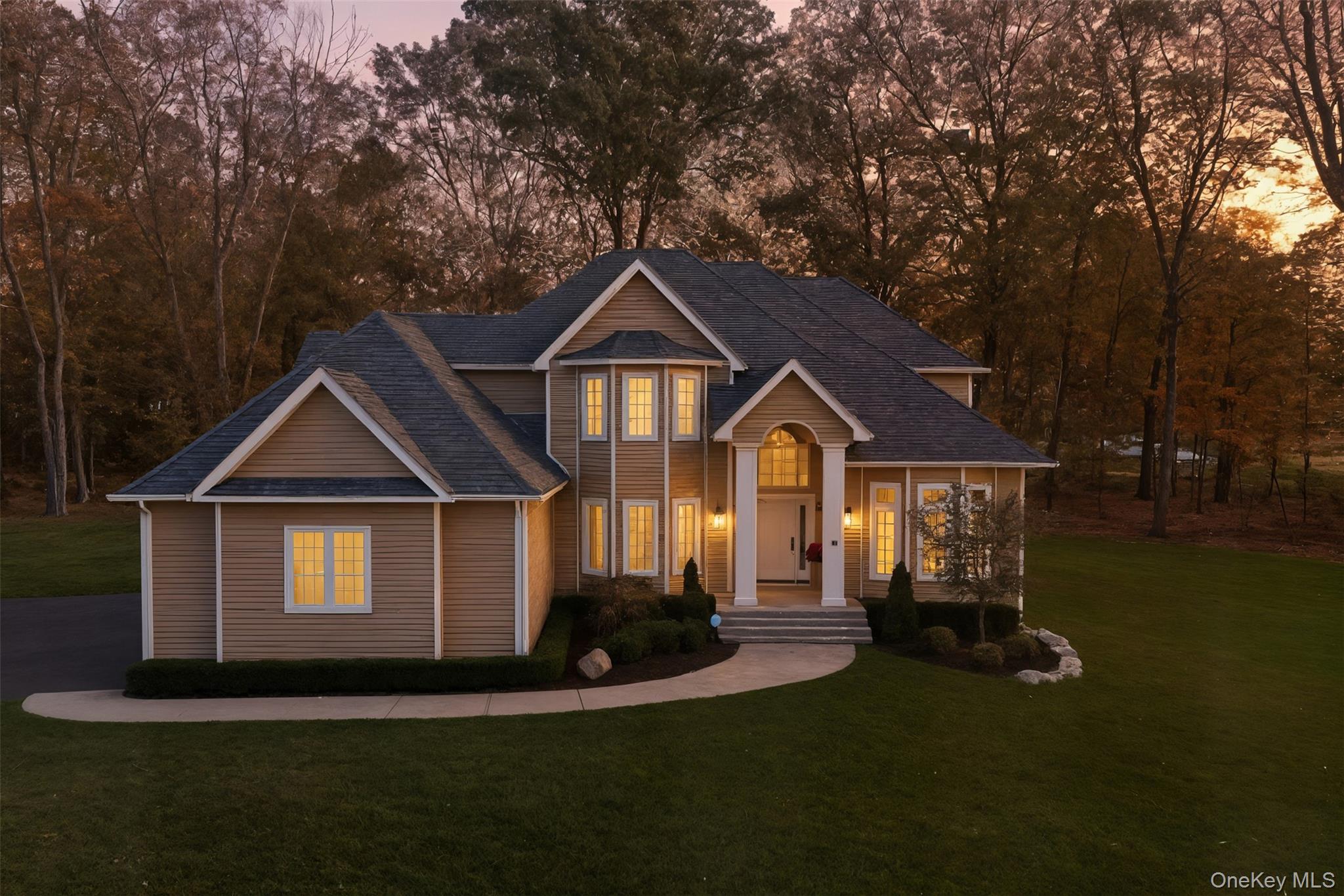 a front view of a house with a yard and trees