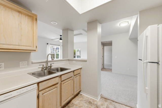 900 Bitner Road, Unit P20 Park City, UT 84098 - Photo 12 of 42 Kitchen featuring light wood-finish cabinetry, solid surface countertops, a stainless steel double basin sink with a chrome faucet, and integrated white appliances