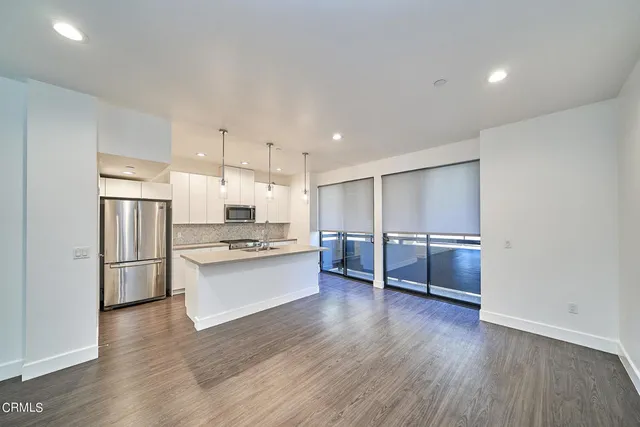 a kitchen with stainless steel appliances a refrigerator and a stove top oven