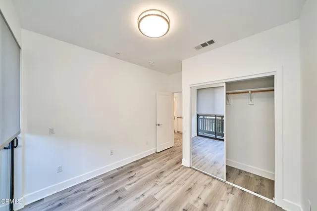 an empty room with wooden floor and mirror