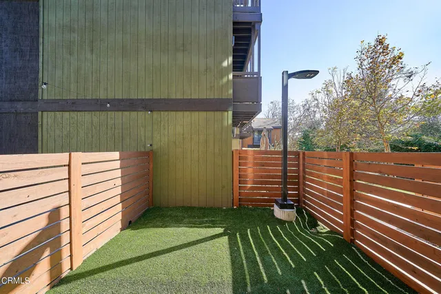 a view of a street with stairs and wooden fence