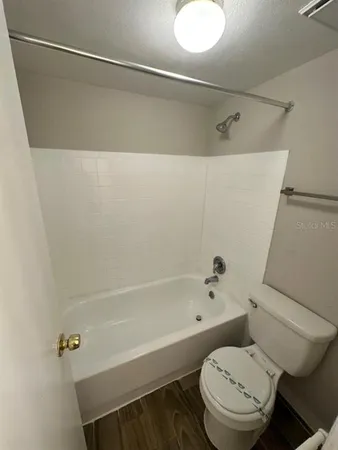a white toilet sitting next to a bath tub