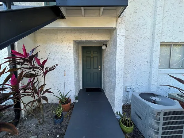 a view of a house with a small yard and potted plants