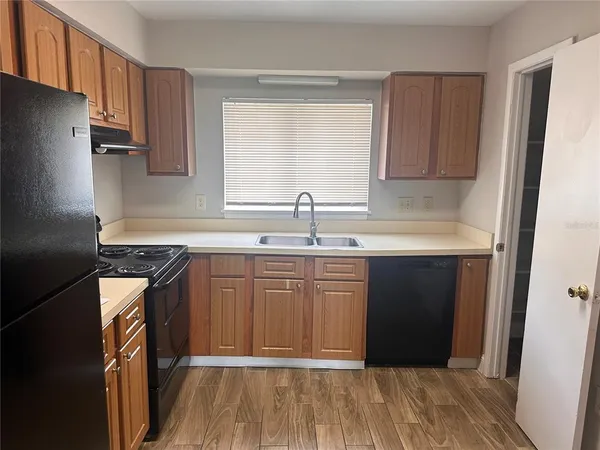 a kitchen with granite countertop a sink stove and refrigerator