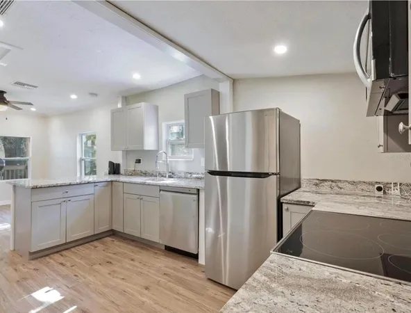 a kitchen with a refrigerator sink and cabinets