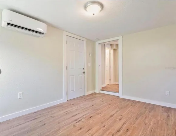 a view of an empty room with wooden floor
