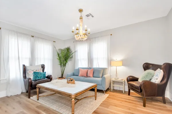 a living room with furniture and a chandelier