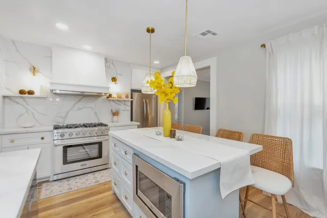 a kitchen with a stove a sink a chandelier and a stove