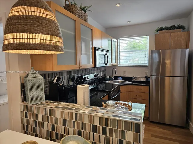 a kitchen with stainless steel appliances granite countertop a stove a sink and a refrigerator