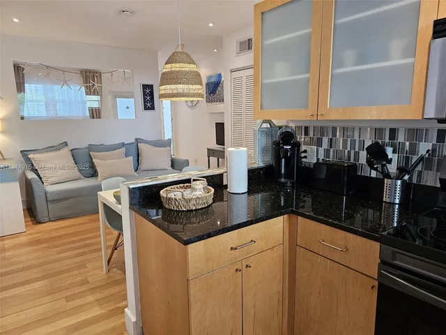 a kitchen with stainless steel appliances kitchen island granite countertop a table and chairs in it