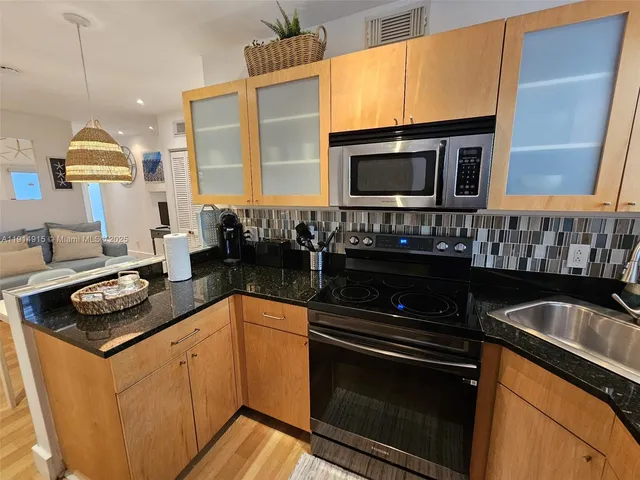 a kitchen with stainless steel appliances granite countertop a stove and a microwave
