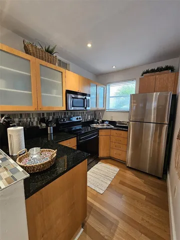 a kitchen with a refrigerator and a stove top oven