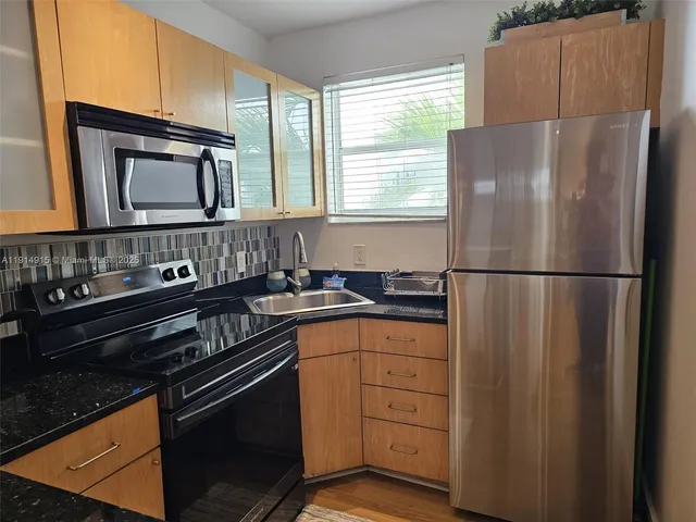 a kitchen with a refrigerator and a sink