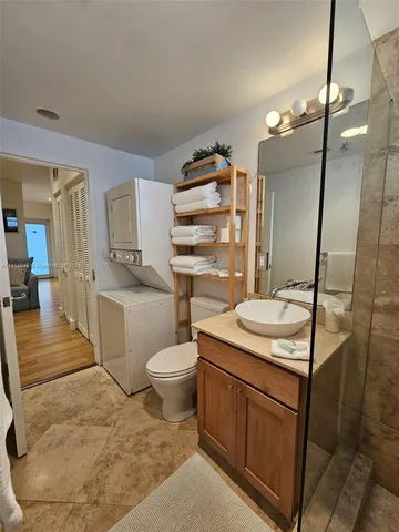 a bathroom with a sink toilet vanity and granite