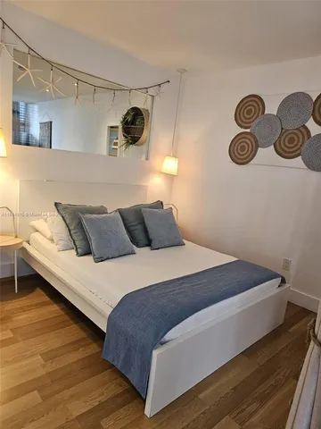 a bedroom with bed and wooden floor