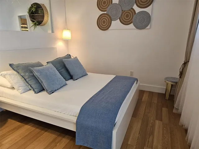 a bedroom with a bed and painting on the wall