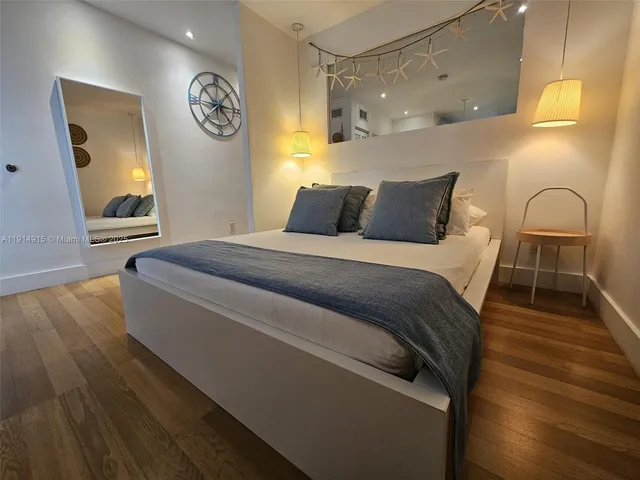 a spacious bedroom with a bed and a dresser next to a window