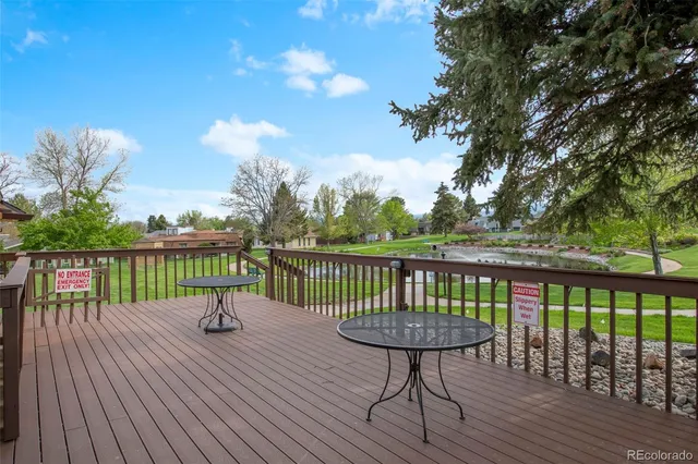 a view of a balcony with wooden floor next to a yard