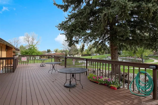 a view of a balcony with wooden floor and outdoor seating