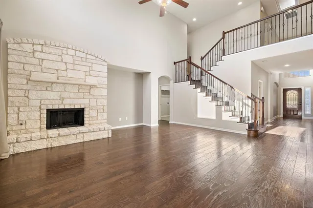 a view of an empty room with wooden floor a fireplace