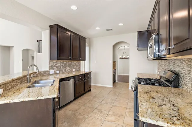 a kitchen with granite countertop stainless steel appliances and sink