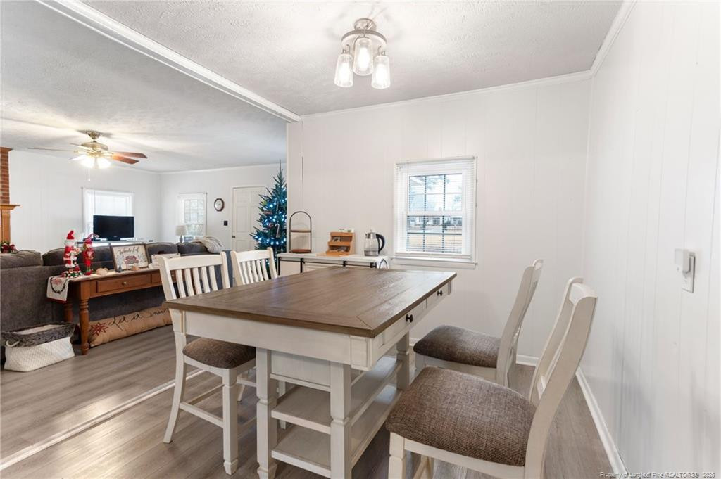 1069 Union Valley Road Whiteville, NC 28472 - Photo 13 of 50 a dining room with furniture a chandelier and wooden floor
