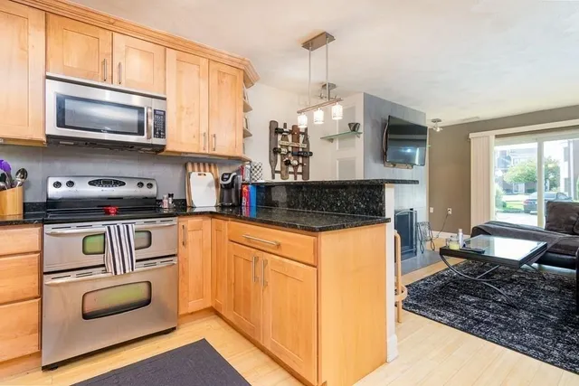 a kitchen with stainless steel appliances granite countertop a stove a sink and a microwave