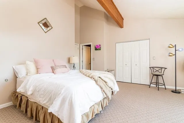 a spacious bedroom with a bed and a chandelier