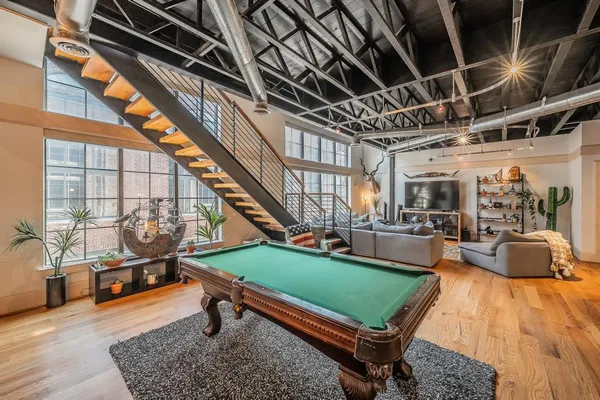 a living room with furniture pool table and a rug