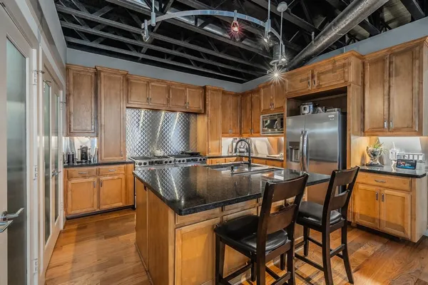 a kitchen with stainless steel appliances granite countertop a stove a sink and a refrigerator