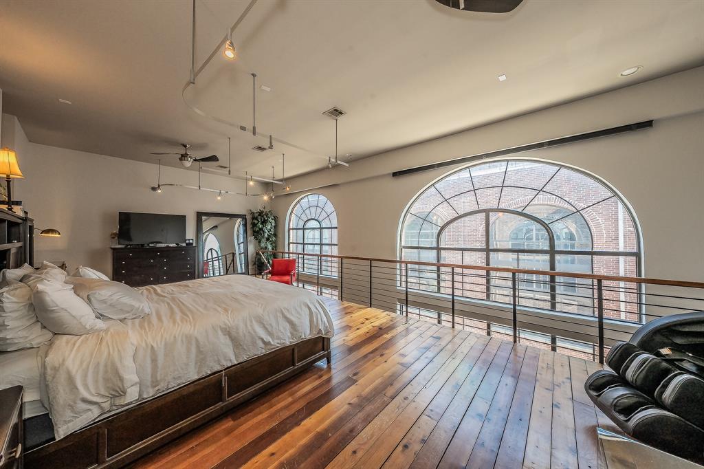 3911 Gilbert Avenue, Unit G Dallas, TX 75219 - Photo 20 of 35 a bedroom with a large bed and a large window