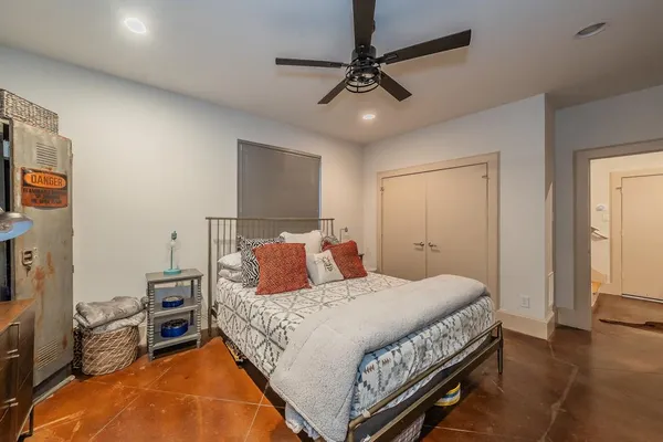 a bedroom with a bed a chandelier and a dresser